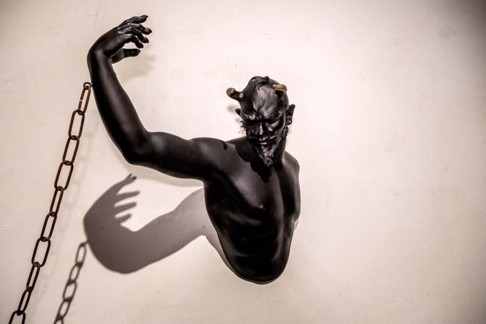 Diavolo nero, incatenato: scultura in terracotta, nera, che rappresenta il busto di un bellissimo, giovane diavolo